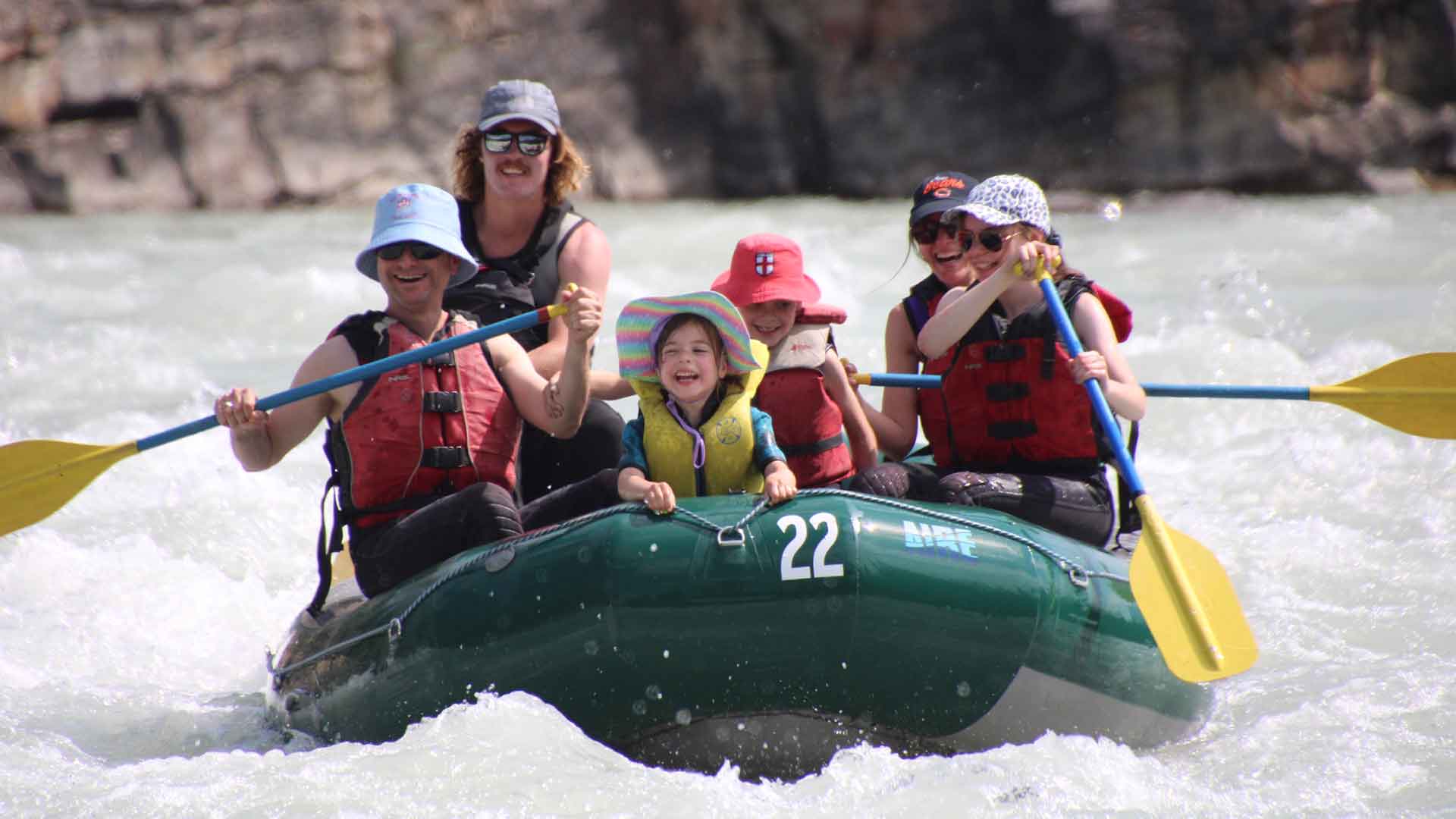 Family paddling together on the Athabasca River with a Jasper Rafting Adventures guide
